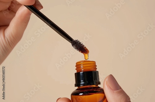 Dropper Dispensing Amber Liquid Into Bottle