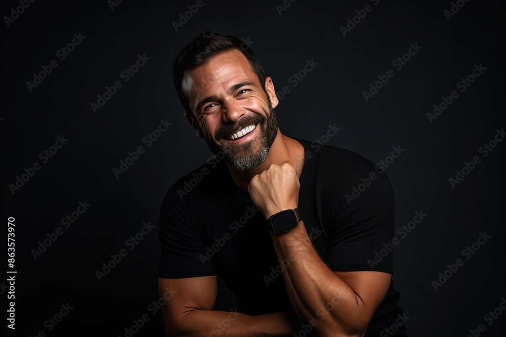 Close up portrait of a handsome middle-aged man in a black t-shirt on a dark background Close up portrait of a handsome middle-aged man in a black t-shirt on a dark background