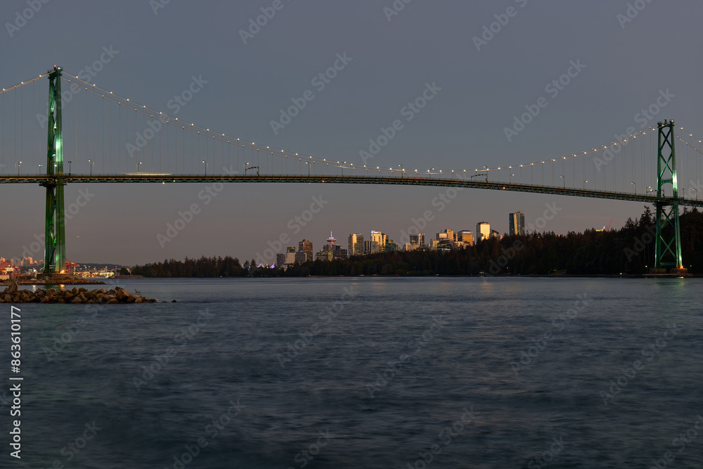 Naklejka premium Vancouver Skyline and Lions Gate Bridge at dusk as seen from Ambleside Park in West Vancouver