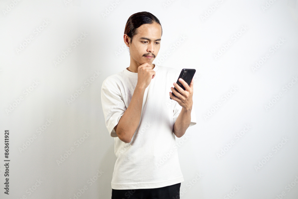 Asian man holding the phone. with a thoughtful expression. isolated in white background Asian man holding the phone. with a thoughtful expression. isolated in white background