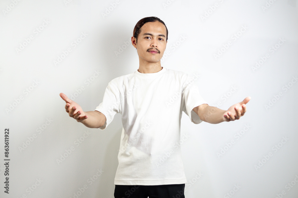 Asian man in white t-shirt pointing forward. isolated on white studio background. Asian man in white t-shirt pointing forward. isolated on white studio background.
