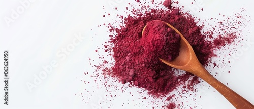 Wooden spoon with vibrant red beetroot powder on a white background. Ideal for culinary, health, and organic food concepts.