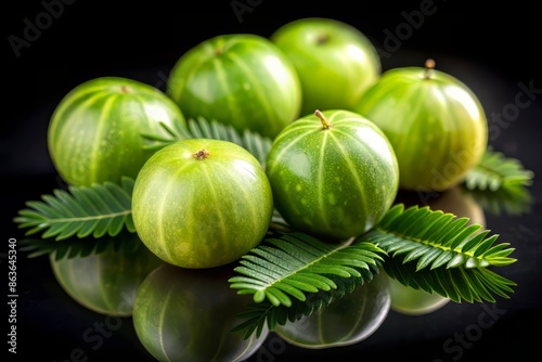 Fresh Indian Gooseberry Amla fruit isolated on black background showcasing its vibrant green color and intricate texture with subtle natural highlights. photo