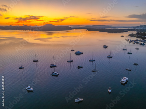 Sunrise over the calm water with boats and reflections photo