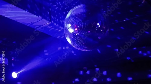 Silver mirror disco ball in the rays of the spotlights