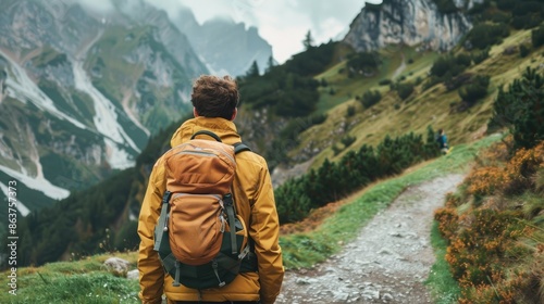 Man with backpack, lost in thought while hiking along a scenic mountain path