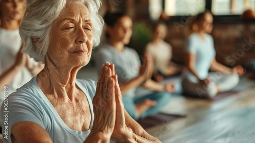 Senior woman practicing yoga with a group in a serene studio. Focused elderly lady meditating. Wellness and mindfulness concept. Group setting for relaxation and peace. Yoga class experience. AI photo