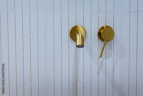 Obraz na płótnie Bronze bathroom water tap in a bathroom finished with white tiles. Minimalist bathroom finish. Photographed in natural light. w salonie