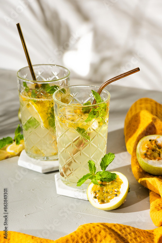 A refreshing summer drink or alcoholic cocktail with passion fruit, ice and lemon on a sunny day. A fresh healthy cold lemonade drink. Sparkling water with lemon.