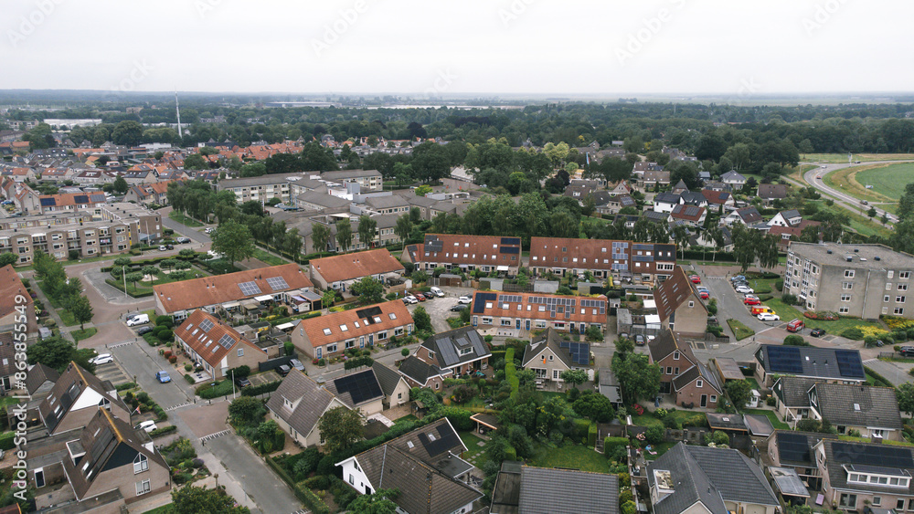 Obraz premium Aerial shot of houses with solar panels on roof in a street in a residential area neighborhood in Steenwijk, Overijssel, The Netherlands.