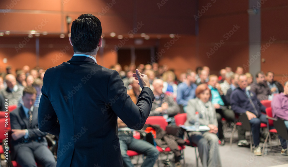 Speaker at Business Conference with Public Presentations. Audience at the conference hall. Entrepreneurship club. Rear view. Panoramic composition. Background blur. Speaker at Business Conference with Public Presentations. Audience at the conference hall. Entrepreneurship club. Rear view. Panoramic composition. Background blur.