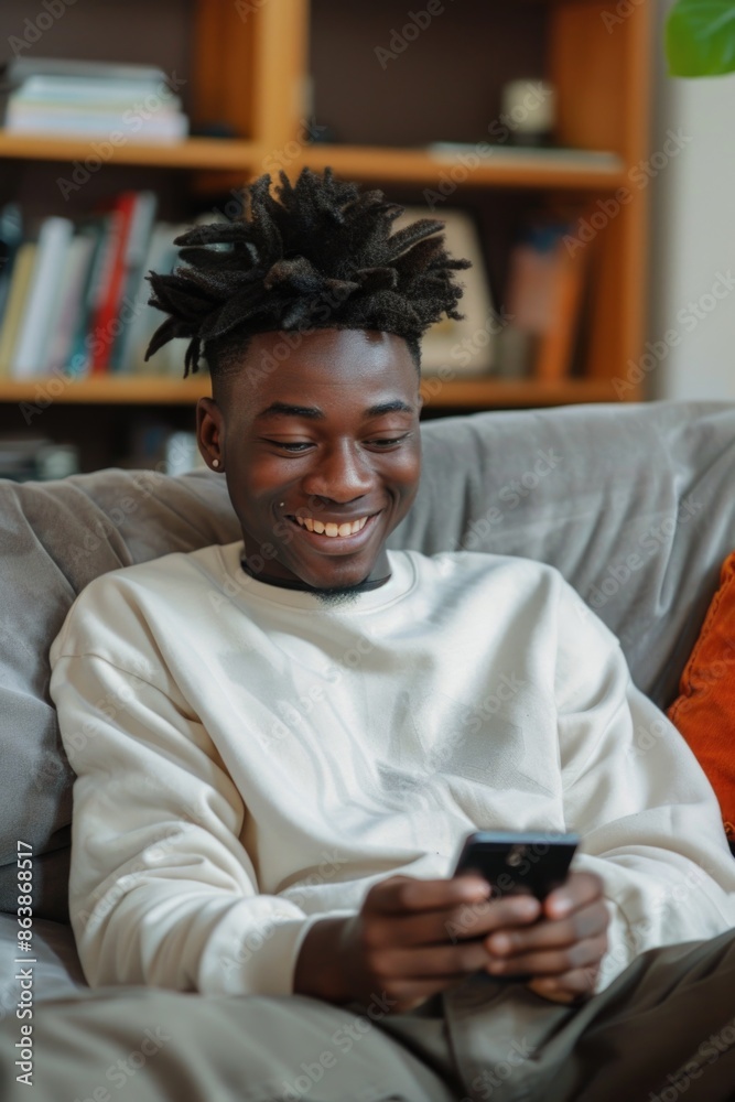 A person sitting on a couch holding a cell phone, possibly watching videos or browsing the internet A person sitting on a couch holding a cell phone, possibly watching videos or browsing the internet