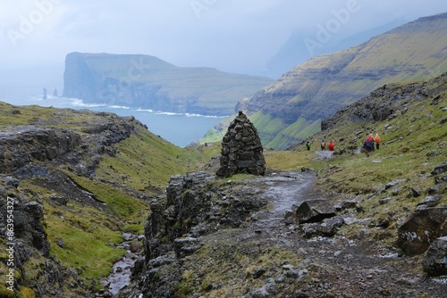 Mountain trip from Saksun village of Saksun to Tjornuvik on island of Streymoy. Silhouettes of hiking people on trail. Faroe Islands, Denmark photo