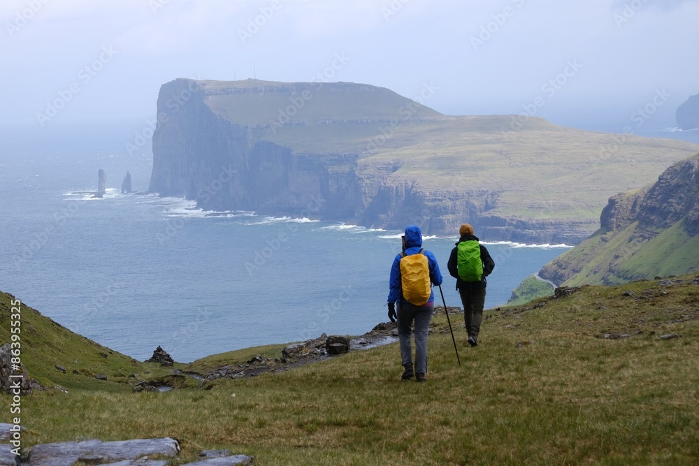Fototapeta premium Mountain trip from Saksun village of Saksun to Tjornuvik on island of Streymoy. Silhouettes of hiking people on trail. Faroe Islands, Denmark
