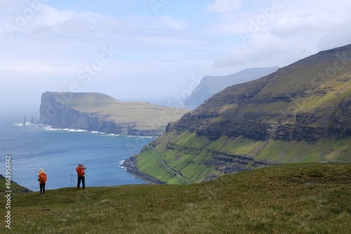 Mountain trip from Saksun village of Saksun to Tjornuvik on island of Streymoy. Silhouettes of hiking people on trail. Faroe Islands, Denmark photo