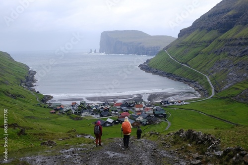 Panorama of Tjornuvik village on island of Streymoy. Silhouettes of hiking people on trail. Faroe Islands, Denmark photo