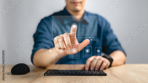 Watching video on internet, live concert, show or tutorial, content on line. Man using mouse and keyboard for streaming on line on virtual screen.