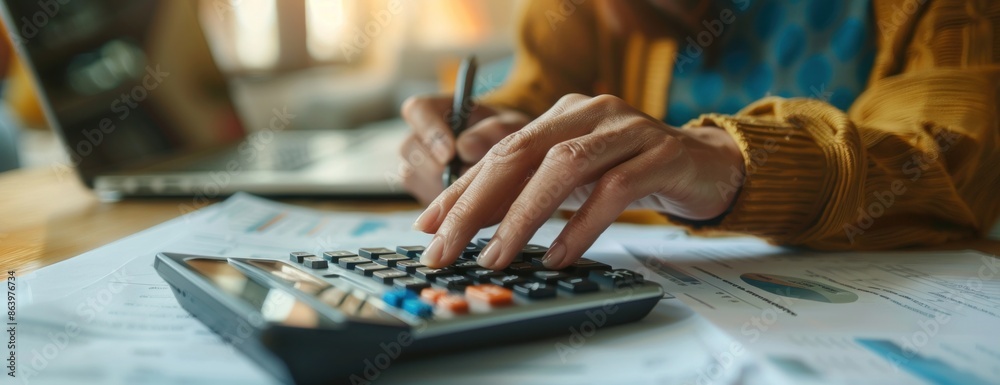 Close-Up of Hands Using Calculator on Desk with Financial Documents Close-Up of Hands Using Calculator on Desk with Financial Documents