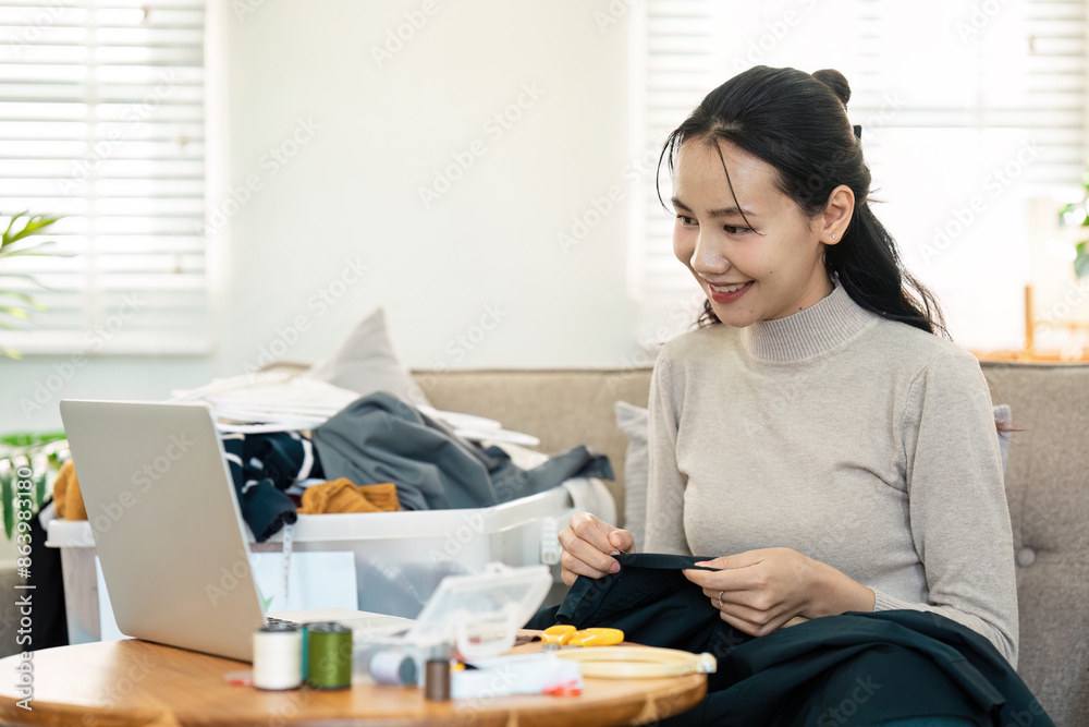 Woman Recycling Clothes at Home with Sewing Kit and Laptop, Promoting Sustainable Fashion and Eco-Friendly Practices Woman Recycling Clothes at Home with Sewing Kit and Laptop, Promoting Sustainable Fashion and Eco-Friendly Practices