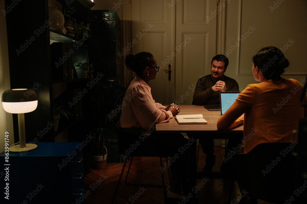 Fototapeta premium Three office coworkers working late at night