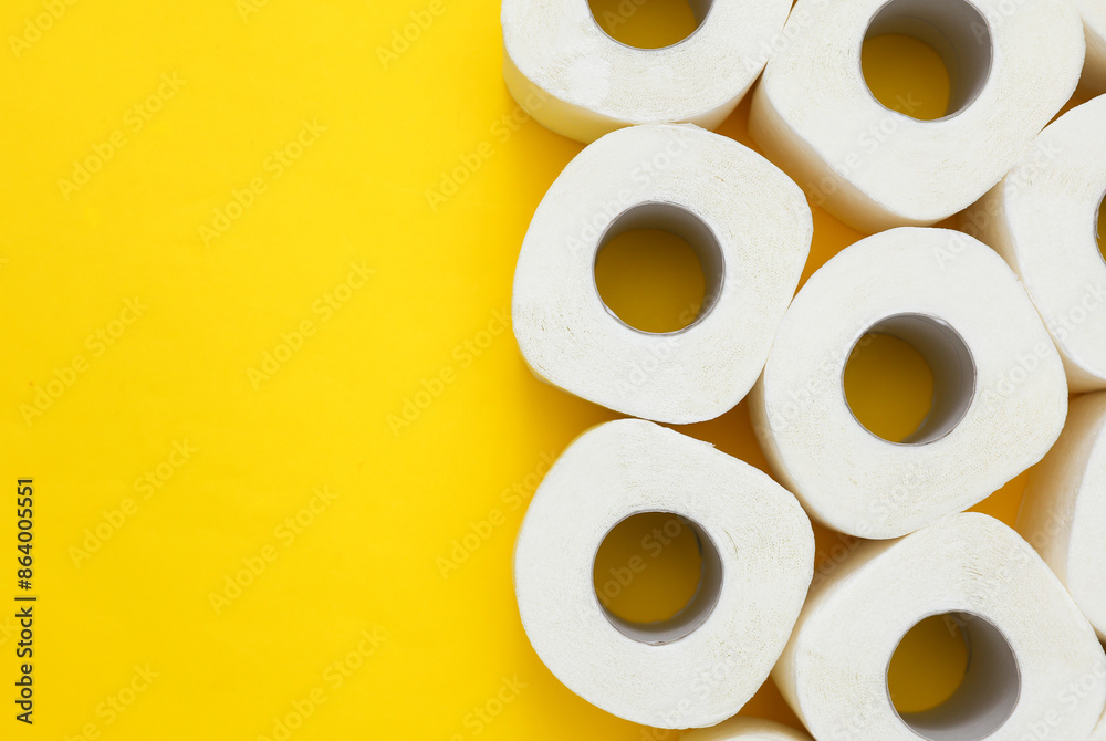 Lots of toilet paper rolls on yellow background. Top view Lots of toilet paper rolls on yellow background. Top view