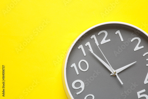 Large round wall clock on yellow background