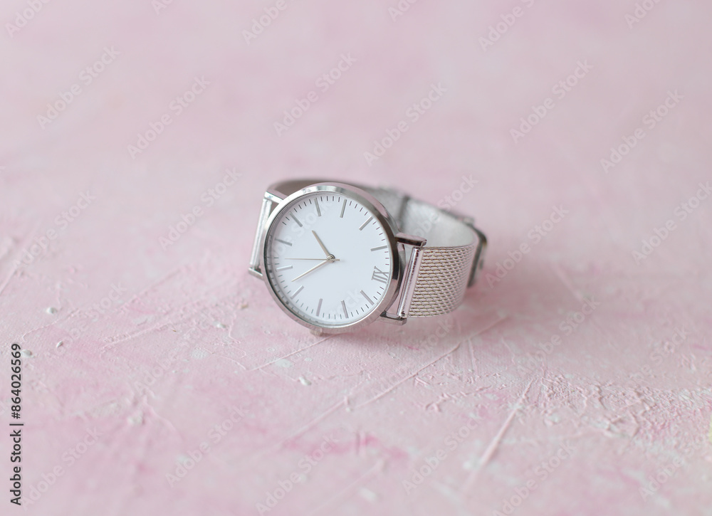 Women's wristwatch on pink concrete background Women's wristwatch on pink concrete background