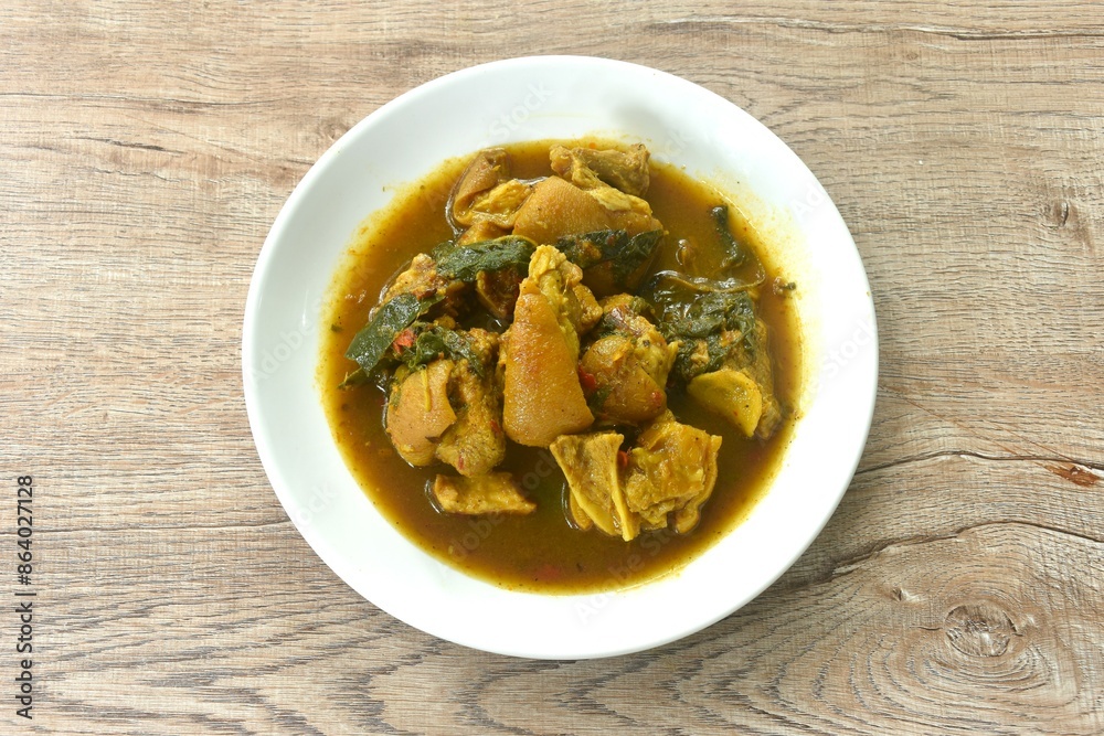 spicy boiled chop pork leg with cumin basil in coconut milk curry soup on plate spicy boiled chop pork leg with cumin basil in coconut milk curry soup on plate