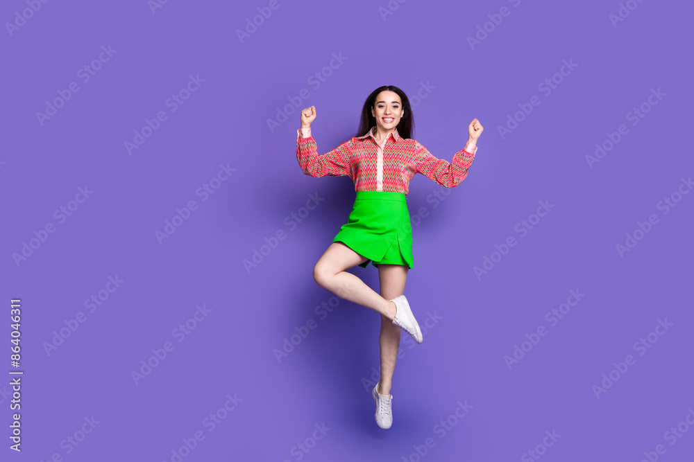 Full body photo of attractive young woman jump winning dressed stylish pink clothes isolated on violet color background Full body photo of attractive young woman jump winning dressed stylish pink clothes isolated on violet color background