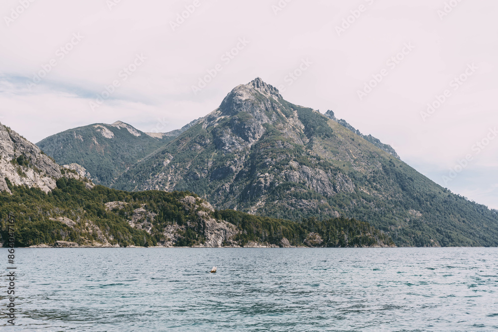 A mountain range is visible in the distance, with a body of water in the foreground. The scene is serene and peaceful, with the mountains and water creating a sense of calm and tranquility A mountain range is visible in the distance, with a body of water in the foreground. The scene is serene and peaceful, with the mountains and water creating a sense of calm and tranquility