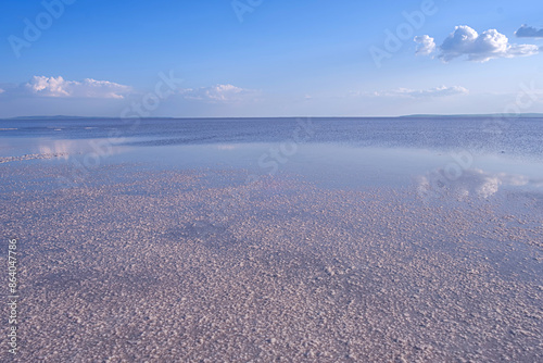 Beautiful mirror reflection on blue sky and cloud on Turkey's salt lake. On the surface of the lake there is a white-brown salt marsh.