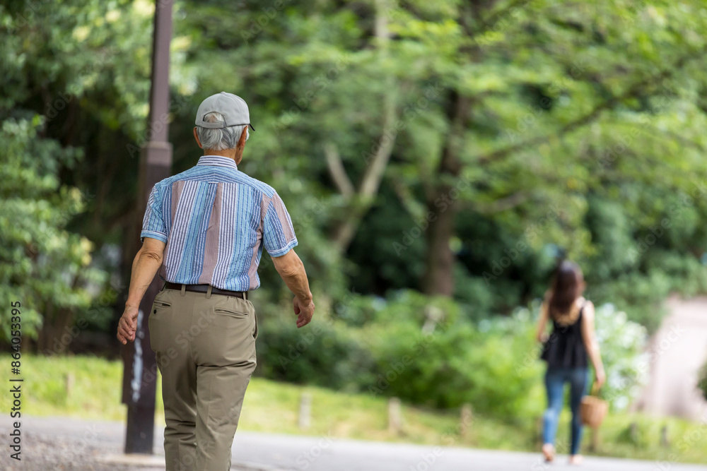 Fototapeta premium 公園をウォーキングする高齢者男性