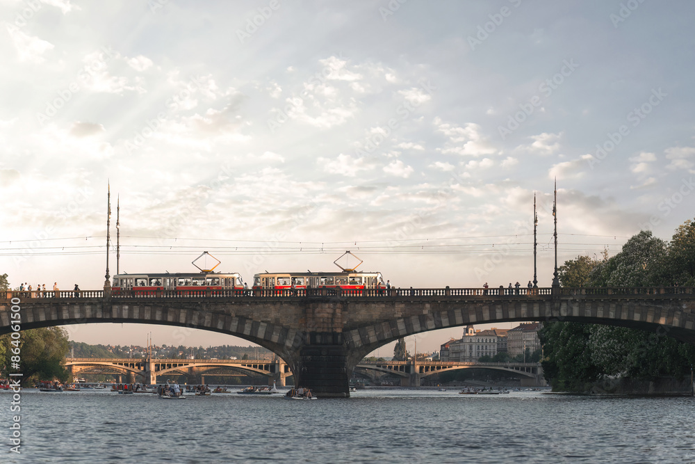 Trams crossing a bridge over the Vltava river in Prague while rowers enjoy the water. Czech Republic Trams crossing a bridge over the Vltava river in Prague while rowers enjoy the water. Czech Republic