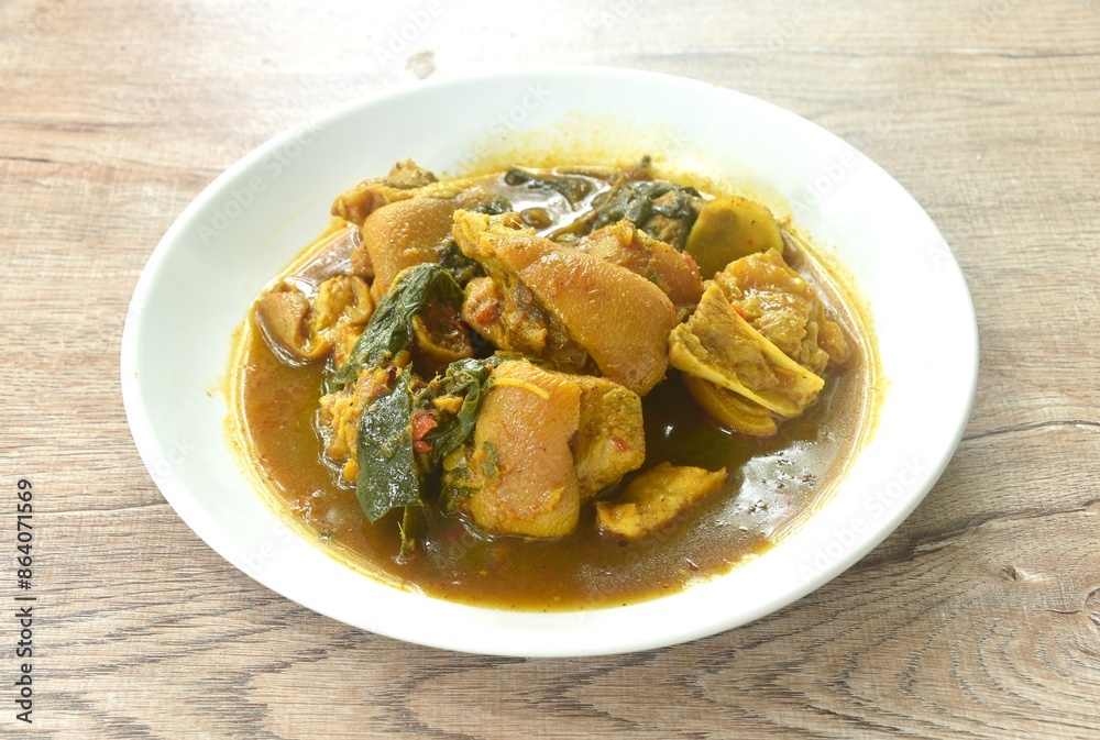 spicy boiled chop pork leg with cumin basil in coconut milk curry soup on plate spicy boiled chop pork leg with cumin basil in coconut milk curry soup on plate