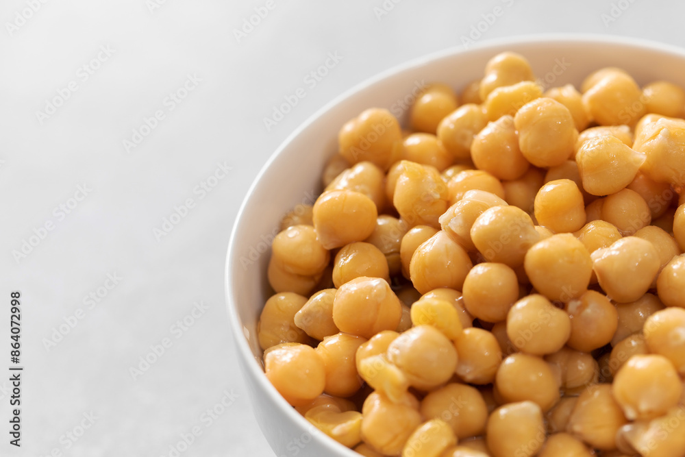 Canned chickpeas in small bowl on light grey background Canned chickpeas in small bowl on light grey background