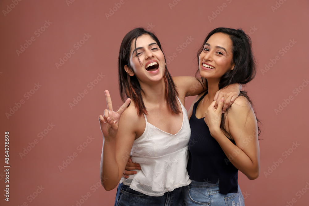 Two Young Charming Women Standing Over Pink Background Two Young Charming Women Standing Over Pink Background