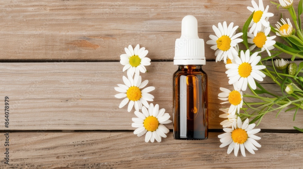 A glass bottle of chamomile essential oil with a dropper sits on a white wooden surface, surrounded by chamomile flowers A glass bottle of chamomile essential oil with a dropper sits on a white wooden surface, surrounded by chamomile flowers