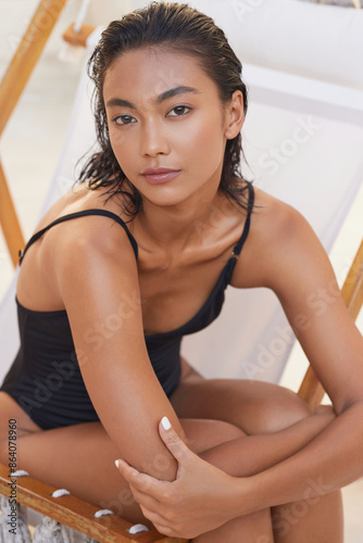 Natural Beauty. Woman With Wet Hair In Black Swimsuit Relaxing On Beach Chair, Exuding Confidence And Tranquility, Highlighting And Summer Vibes.