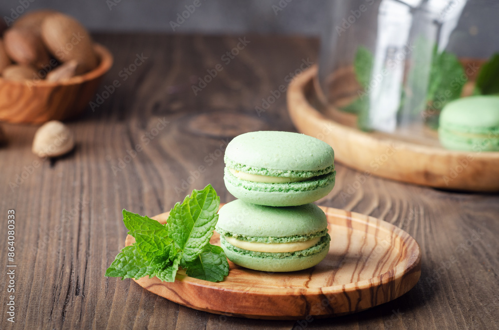 Green macarons with fresh mint on rustik wooden table. Green macarons with fresh mint on rustik wooden table.