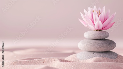 Elegant arrangement of zen stones and lotus flower on velvet sand, set against a soft pink background, conveying peace and tranquility for spa imagery