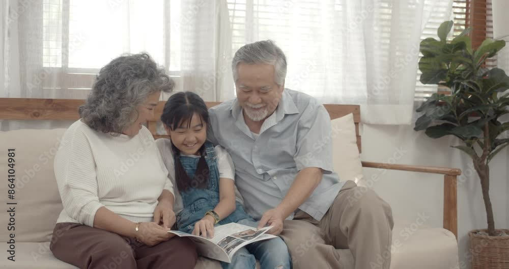 Grand parents spend times on holiday with granddaughter in living room at home.