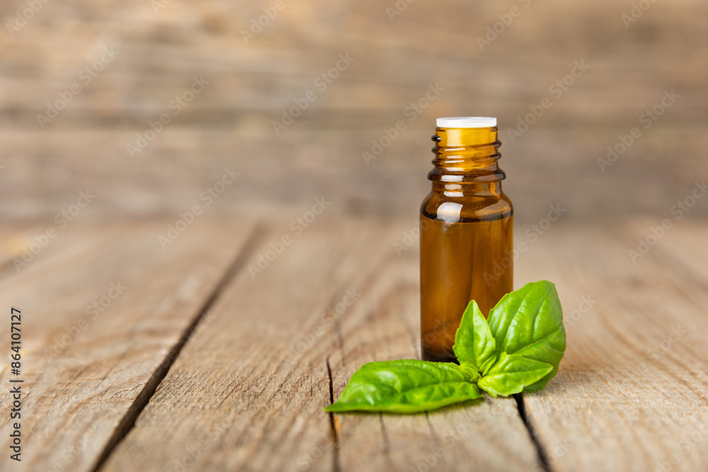 Basil essential oil on a textured wooden background. Basil essential oil and fresh leaves. Aromatherapy. Aroma oil. Medical herbs. Alternative medicine. Place for text. Copy space.