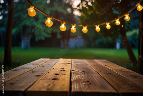 Empty Wood table top with decorative outdoor string lights hanging on trees in the revier nature  at sunset time, photo