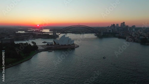 Royal Botanic Gardens Sydney Opera House Harbour Bridge Vivid Australia aerial drone tourist city Circular Quay scenic helicopter flight ferry boats orange dusk evening sunset backwards movement photo