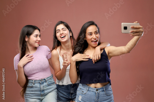 Three Lovely Friends Smiling And Taking A Selfie