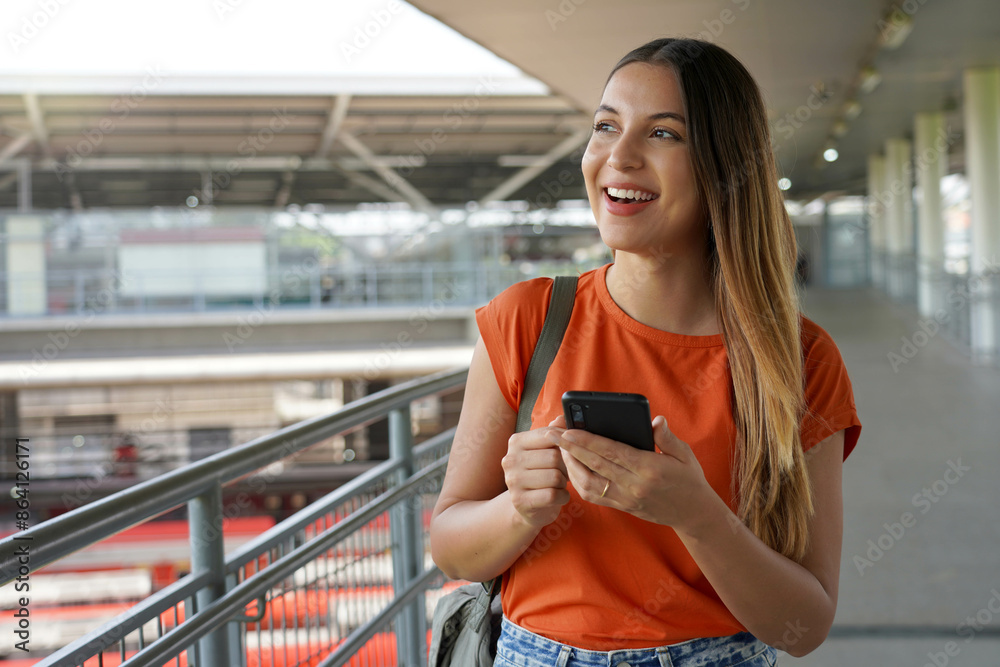 Brazilian girl walking and holding smartphone in Sao Paulo, Brazil