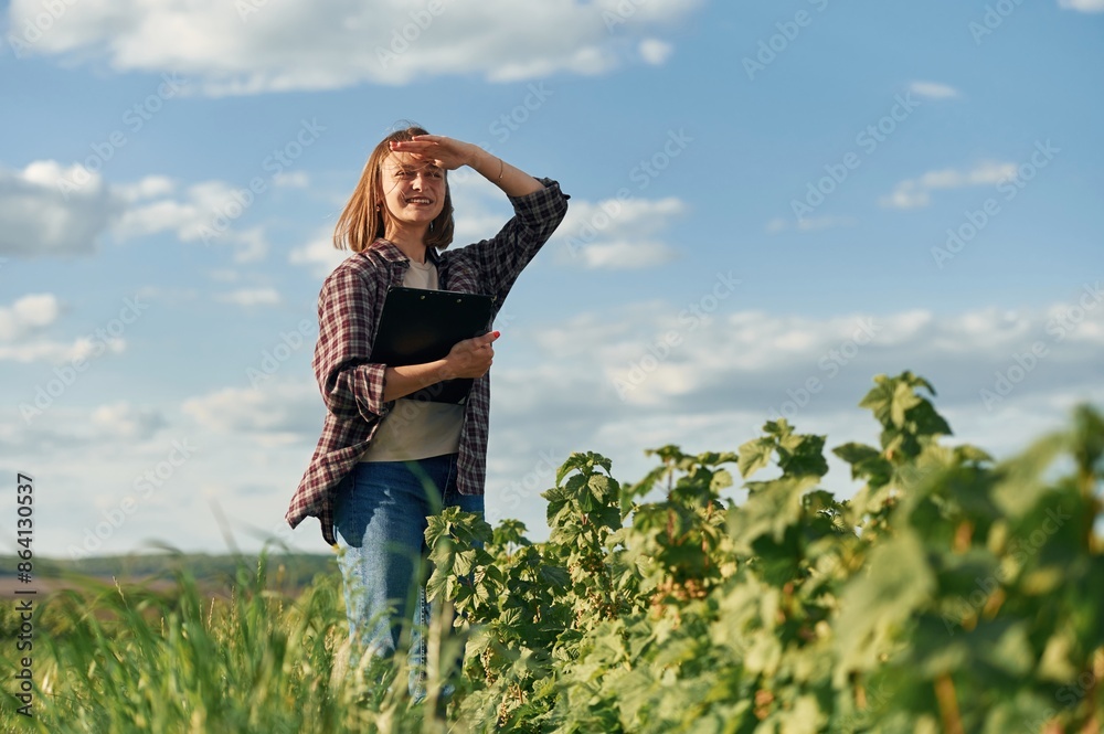 Young woman is on the beautiful agricultural field at daytime Young woman is on the beautiful agricultural field at daytime