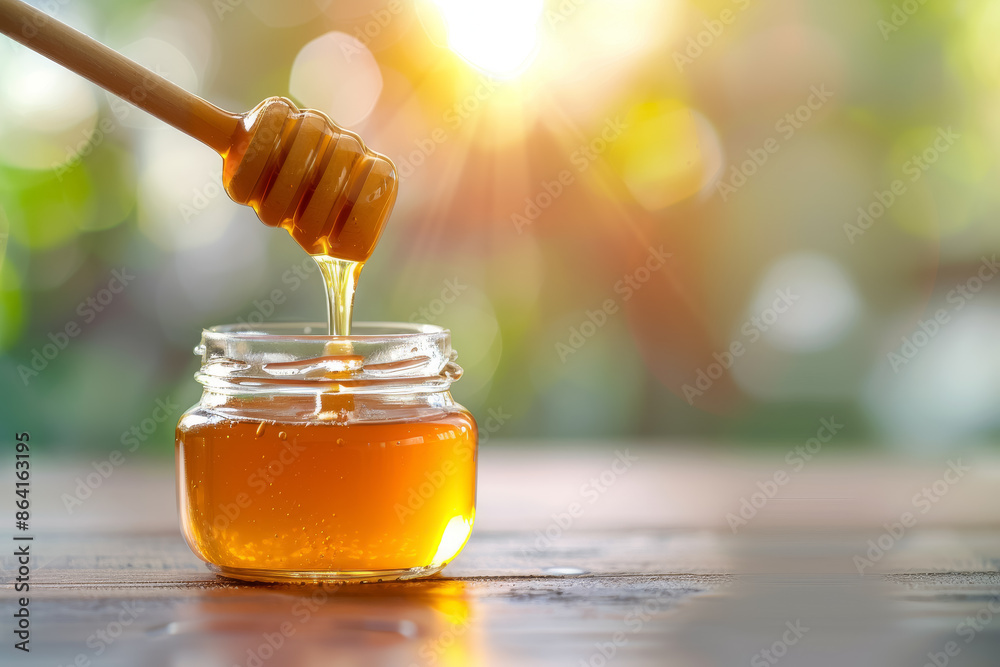 Glass jar filled with golden honey, with a honey dipper immersed and natural sunlight background. Perfect for culinary or natural lifestyle themes. Glass jar filled with golden honey, with a honey dipper immersed and natural sunlight background. Perfect for culinary or natural lifestyle themes.