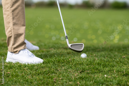 Close up of a guys feet in sneakers on the grass playing gold photo