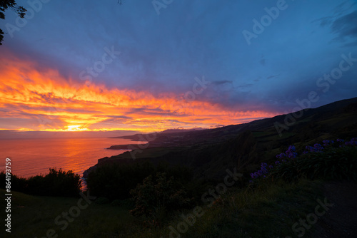 A beautiful sunset over the ocean with a mountain in the background